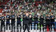 FIFA President Gianni Infantino applauds the Qatar players as they are presented with their third place medals.
