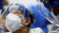 A woman reacts as she receives the first dose of China's Sinovac Biotech vaccine against the coronavirus disease (COVID-19), during a mass vaccination program for the elderly, at the Bolivarian Technology Institute in Guayaquil, Ecuador April 15, 2021. REUTERS/Santiago Arcos

