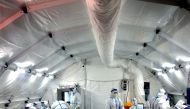 Medical workers in protective suits work inside a makeshift nucleic acid testing laboratory set up at a convention centre following the coronavirus disease (COVID-19) outbreak in Xian, Shaanxi province, China December 22, 2021. Picture taken December 22, 2021. cnsphoto via REUTERS