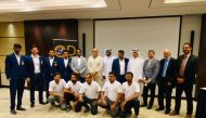 Officials and Qatar deaf cricket team players pose for a photograph following a press conference held in Doha.
