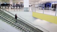 A flight crew member stands on an escalator in the international terminal at Sydney Airport, as countries react to the new coronavirus Omicron variant amid the coronavirus disease (COVID-19) pandemic, in Sydney, Australia, November 30, 2021. REUTERS/Loren Elliott/File Photo