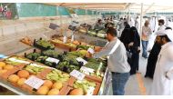 People buying local vegetables at a market.