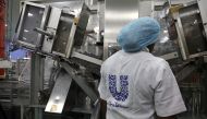 A woman stands behind a machine that is part of a toothpaste manufacturing line at the Unilever factory in Lagos, Nigeria January 18, 2018. Picture taken January 18, 2018. REUTERS/Afolabi Sotunde/File Photo