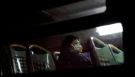 A woman wearing a protective face mask sits on a bus, following new cases of the coronavirus disease (COVID-19), in Shanghai, China January 20, 2022. REUTERS/Aly Song/File Photo