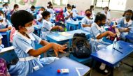 Students apply hand sanitiser while attending a class at the Viqarunnisa Noon School & College after the government has withdrawn restrictions on educational institutions following a decrease in the number of cases of coronavirus disease (COVID-19) in Dhaka, Bangladesh, September 12, 2021. REUTERS/Mohammad Ponir Hossain/File Photo