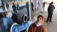 A healthcare worker collects a test swab sample from a woman amidst the spread of the coronavirus disease (COVID-19), at a testing centre inside a hospital in New Delhi, India, January 14, 2022. REUTERS/Anushree Fadnavis/File Photo