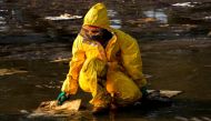 A worker cleans oil spills caused by a leak from an undersea pipeline 20 km (12.4 miles) off Thailand's eastern coast at Mae Ramphueng beach in Rayong province, Thailand, January 29, 2022. REUTERS/Athit Perawongmetha