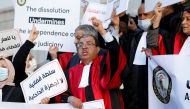 Tunisian judges display signs and banners during a protest against President Kais Saied's move to dissolve the Supreme Judicial Council, in Tunis, Tunisia, February 10, 2022. REUTERS.