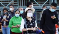 A woman wearing a face mask and a face shield lines up among people at a makeshift testing site for the coronavirus disease (COVID-19) following the outbreak, in Hong Kong, China February 11, 2022. REUTERS/Joyce Zhou
