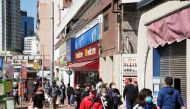Pedestrians wearing face masks walk on a street, following the coronavirus disease (COVID-19) outbreak in Hong Kong, China February 14, 2022. REUTERS/Lam Yik

