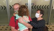 Rudolf and Julianna Nemeth from Hungary reunite with their granddaughter Lili as they arrive on the first international flight to the Brisbane International Airport, Australia February 21, 2022. AAP Image/Darren England via Reuters