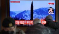 People watch a TV broadcasting file footage of a news report on North Korea firing what appeared to be a ballistic missile, in Seoul, South Korea, February 27, 2022. Yonhap via Reuters