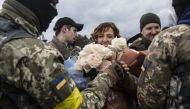 Members of the Territorial Defense Forces give roses to Filimonova. Photo by Heidi Levine for The Washington Post.