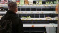 FILE PHOTO: A customer wearing a face mask shops in front of partially empty shelves at a supermarket, following the outbreak of the coronavirus disease (COVID-19), at Sha Tin district, in Hong Kong, China, February 7, 2022. REUTERS/Lam Yik



