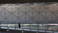 A traveller wearing a protective face mask walks through the Hong Kong International Airport during the coronavirus disease (COVID-19) pandemic in Hong Kong, China, March 17, 2022. REUTERS/Tyrone Siu