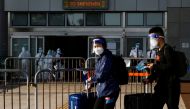 FILE PHOTO: Travellers wearing face mask and shield, walk at the China-Hong Kong border of Shenzhen Bay Port, during the coronavirus disease (COVID-19) pandemic in Hong Kong, China, March 14, 2022. REUTERS/Tyrone Siu