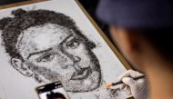 Artist and Filipino seafarer Jesstoni Garcia works on a portrait of Rihanna, made out of human hair, in San Juan City, Philippines, March 10, 2022. Picture taken March 10, 2022. REUTERS/Eloisa Lopez