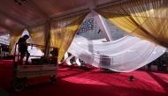 A worker puts the last minute touches on the red carpet arrivals area as preparations continue in Hollywood for the Academy Awards in Los Angeles, California, U.S., March 26, 2022. REUTERS/Mike Blake