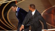 Will Smith (R) hits Chris Rock as Rock spoke on stage during the 94th Academy Awards in Hollywood, Los Angeles, California, U.S., March 27, 2022. REUTERS/Brian Snyder