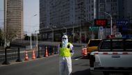 A police officer in a protective suit keeps watch near a bridge leading to the Pudong area across the Huangpu river, after traffic restrictions amid the lockdown to contain the spread of the coronavirus disease (COVID-19) in Shanghai, China March 28, 2022. REUTERS/Aly Song