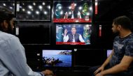 People watch the speech of Pakistani Prime Minister Imran Khan on television screens, in Islamabad, Pakistan, March 31, 2022. REUTERS/Akhtar Soomro
