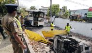 Sri Lankan crime scene officers inspect damaged vehicles after they were set on fire by demonstrators at the top of the road to Sri Lankan President Gotabaya Rajapaksa's residence during a protest against him in Colombo, Sri Lanka April 1, 2022. Reuters/Dinuka Liyanawatte