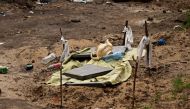 A grave where two men have been buried, who according to residents were shot dead in the eye by Russian soldiers, is seen at the garden of a building, amid Russia's invasion on Ukraine, in Bucha, Ukraine April 3, 2022. REUTERS.