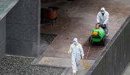 Workers in protective suit spray disinfectant at a community, during the lockdown to curb the spread of the coronavirus disease (COVID-19) in Shanghai, China, April 5, 2022. Reuters/Aly Song
 