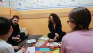 Regina Nasretdinova interact with Ukrainian children, who fled the Russian invasion of Ukraine, during an art therapy class at the Berehynia Cultural and Educational Center in Athens, Greece, March 28, 2022. REUTERS/Louiza Vradi