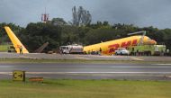Firefighters work at the scene where a Boeing 757-200 cargo aircraft operated by DHL made an emergency landing before skidding off the runway and splitting, aviation authorities said, at the Juan Santamaria International Airport in Alajuela, Costa Rica April 7, 2022. REUTERS/Mayela Lopez
