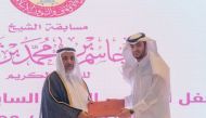 Minister of Awqaf and Islamic Affairs H E Ghanem bin Shaheen bin Ghanem Al Ghanem honouring a winner of 27th Sheikh Jassim bin Muhammad bin Thani Holy Quran Competition.