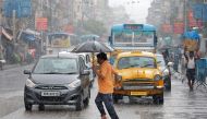 A man carrying an umbrella runs as he crosses a busy road during rain in Kolkata, India, July 10, 2018. REUTERS/Rupak De Chowdhuri


