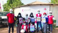 QRCS volunteers distributing sanitation and hygiene kits to people in Gambia.