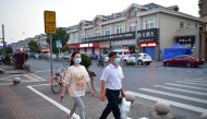 Residents walk on a street in Fengjing town of Jinshan district, as the city eases the lockdown in some areas amid the coronavirus disease (COVID-19) outbreak, in Shanghai, China April 11, 2022. Picture taken April 11, 2022. 