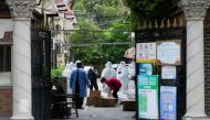 Workers in protective suits are seen at a residential area under lockdown amid the coronavirus disease (COVID-19) pandemic, in Shanghai, China April 15, 2022. REUTERS/Aly Song