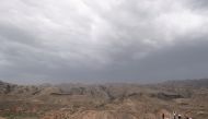Tourists stand on a hill overlooking an arid terrain in the south of Ningxia Hui Autonomous Region, China July 27, 2021. Picture taken July 27, 2021. REUTERS/Ryan Woo