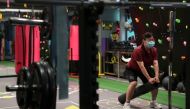 A woman wearing a face mask exercises at a gym on the day of its reopening following the coronavirus disease (COVID-19) outbreak, in Hong Kong, China, April 21, 2022. REUTERS/Lam Yik