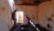 Men dig mud out of a house after heavy rains caused flooding in Ntuzuma near Durban, South Africa, April 20, 2022. REUTERS/Rogan Ward