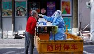 A medical worker in a protective suit collects a swab from a resident for nucleic acid testing, amid the coronavirus disease (COVID-19) outbreak in Shanghai, China April 22, 2022. cnsphoto via REUTERS