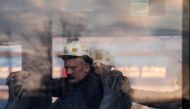Miners looks from a window as search and rescue operation continues after a tremor at the Borynia-Zofiowka coal mine in Jastrzebie-Zdroj, Poland. April 23, 2022. Picture taken April 23, 2022. Dominik Gajda/Agencja Wyborcza.pl via REUTERS