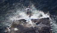 An aerial view shows a Japan Coast Guard helicopter conducts a search and rescue operations for missing people boarded on the missing tour boat 