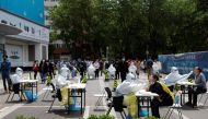 Medical workers in protective suits collect swabs from residents at a makeshift nucleic acid testing site amid the coronavirus disease (COVID-19) outbreak in Beijing, China April 28, 2022. Reuters/Carlos Garcia Rawlins