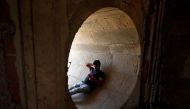 A man rests in a dry water tunnel of the Sarkhej Roza lake during hot weather in Ahmedabad, India, April 28, 2022. REUTERS/Amit Dave