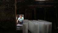 A worker waits to load ice blocks onto a truck, at an ice factory, on a hot summer day in New Delhi, India, May 1, 2022. REUTERS/Anushree Fadnavis

