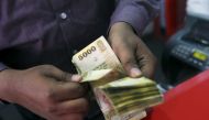 A man counts Sri Lankan rupees at a money exchange counter in Colombo September 4, 2015. REUTERS/Dinuka Liyanawatte

