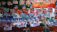 A man sits below election posters a day prior to the national elections in Manila, Philippines, May 8, 2022. REUTERS/Willy Kurniawan