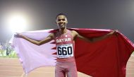 Abdul Rahman Hassan celebrates with the Qatari flag after winning men’s 800m race.