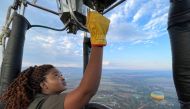 Semakaleng Mathebula, South Africa's first Black female hot-air balloon pilot releases propane gas into the burner of a hot-air balloon during a flight over Johannesburg, South Africa, May 15, 2022. REUTERS/Shafiek Tassiem NO RESALES. NO ARCHIVES