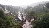 A river runs high after heavy rains, next to homes which were damaged during previous flooding, in kwaNdengezi near Durban, South Africa, May 22, 2022. REUTERS/Rogan Ward
