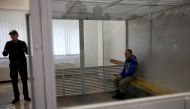 Russian soldier Vadim Shishimarin, 21, suspected of violations of the laws and norms of war, sits inside a cage during a court hearing, amid Russia's invasion of Ukraine, in Kyiv, Ukraine May 23, 2022. Reuters/Viacheslav Ratynskyi
